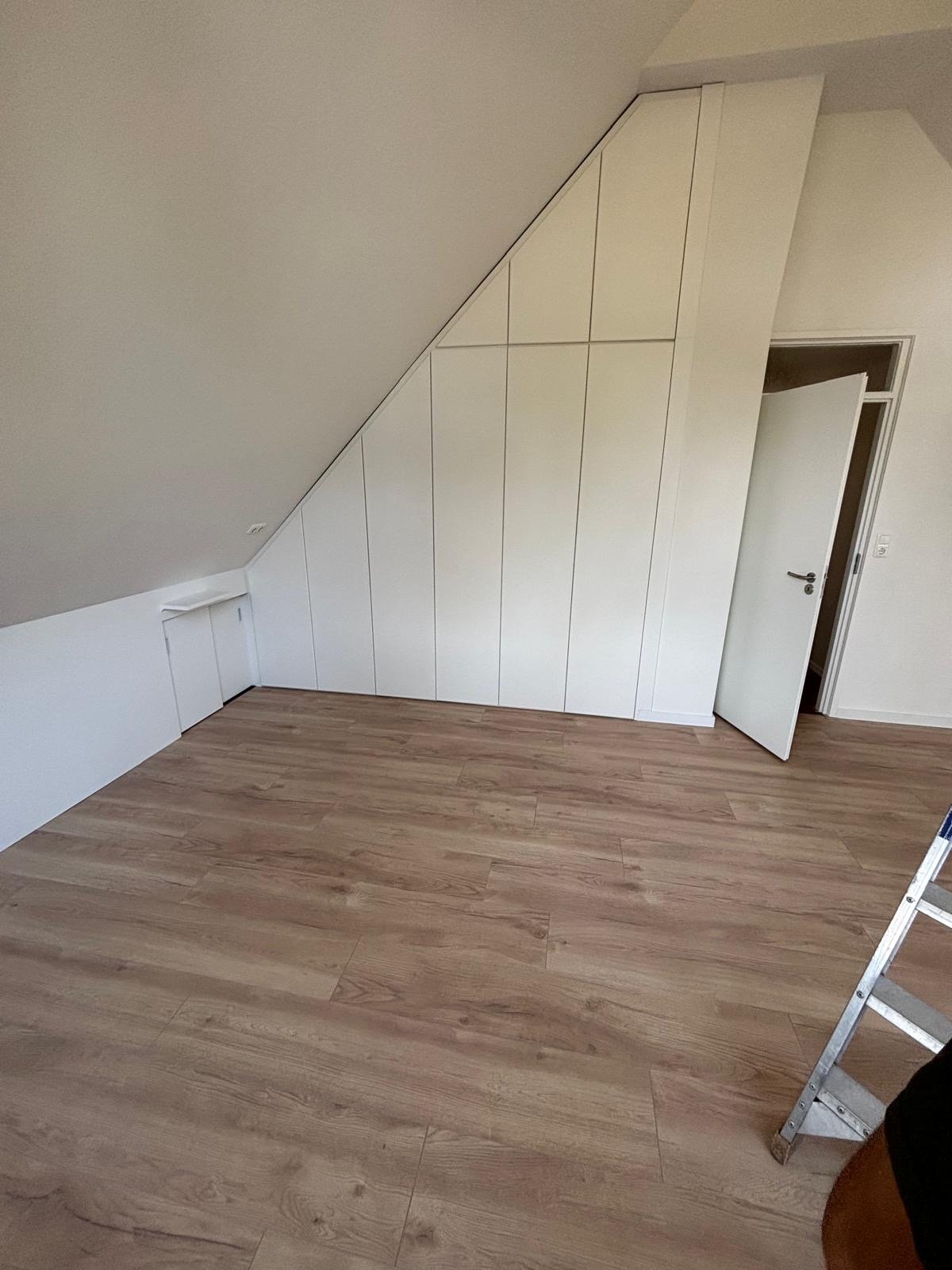 Witte schuine kast op zolderkamer